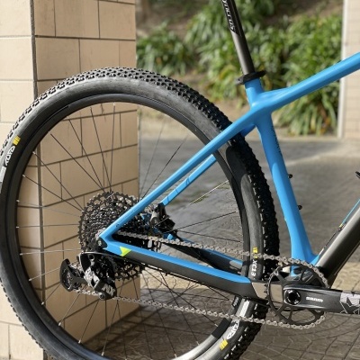Bicicleta de montanha azul e preta com pneus cravados