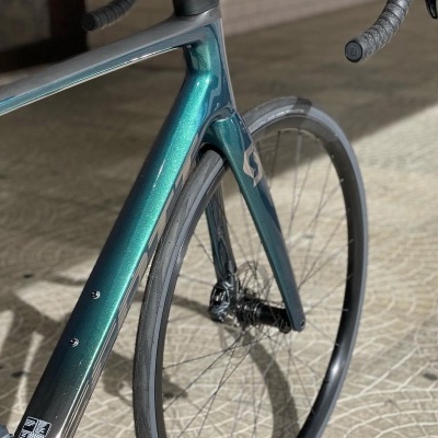 Quado e roda dianteira de bicicleta de estrada verde e preta em piso de azulejo