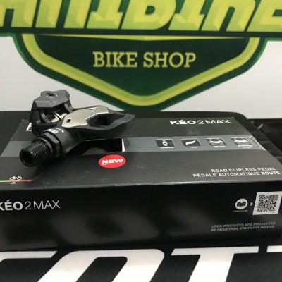 Pedal de bicicleta KÉO 2 MAX cinza e preto em cima da caixa preta com texto branco