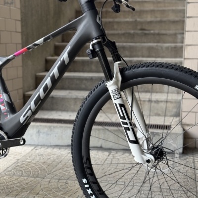 Bicicleta de montanha preta e branca com logotipos SCOTT e ROCK SHOX SID