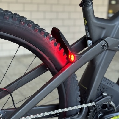 Bicicleta preta com luz traseira vermelha e pneus para todo-terreno
