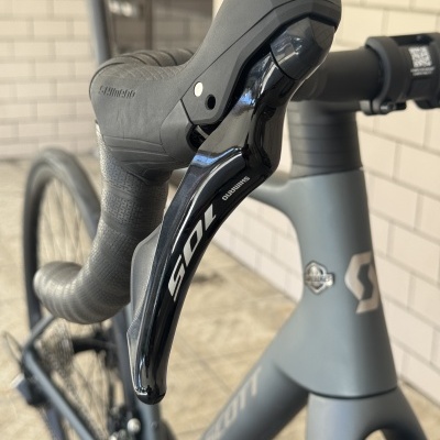 Punho e manete de bicicleta Shimano 105 preto com quadro Scott cinzento mate.