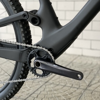 Detalhe de bicicleta de montanha preta com quadro mate e pedalier XT