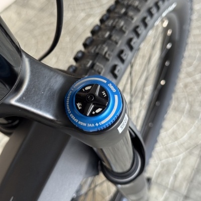 Suspensão de bicicleta com ajuste azul e pneu preto texturizado