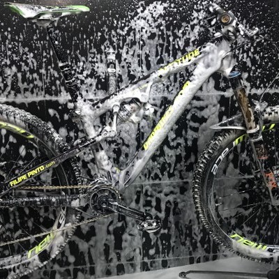 Bicicleta de montanha cinzenta e amarela com espuma de lavagem no fundo preto