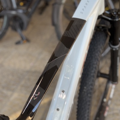 Quadro de bicicleta branca e preta com o nome SPARK e pneu de montanha