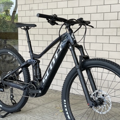 Bicicleta de montanha elétrica Scott preta encostada a parede