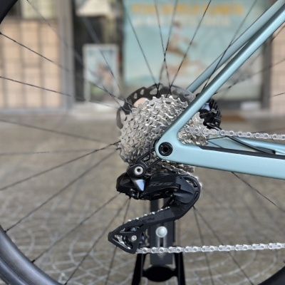 Roda traseira de bicicleta com quadro azul claro e componentes metálicos e pretos