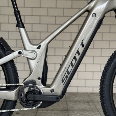 Bicicleta elétrica SCOTT prateada com componentes pretos e pneus off-road