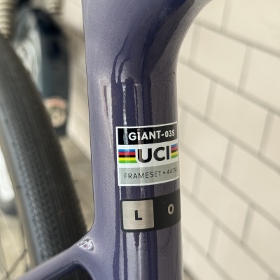 Parte do quadro de bicicleta azul metálico com autocolantes GIANT-035 e UCI