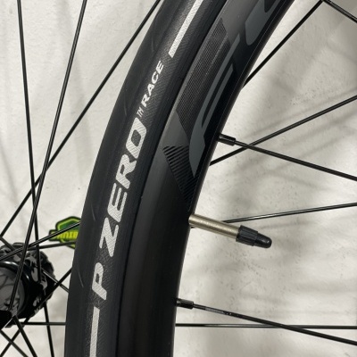 Roda de bicicleta preta com pneu P ZERO RACE e raios finos