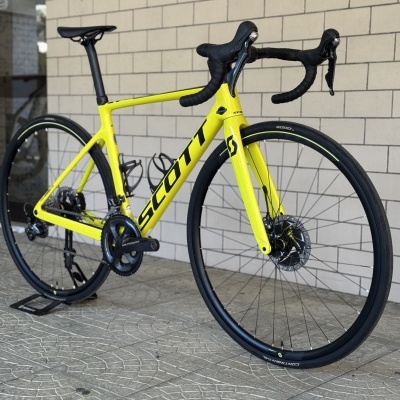 Bicicleta de estrada amarela SCOTT com rodas pretas e guiador curvo preto.
