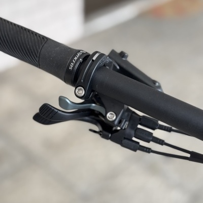 Punho e manete de bicicleta pretos com cabos e anilha com texto SQiRATTOS