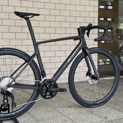 Bicicleta de carbono preta com pneus finos e componentes Shimano