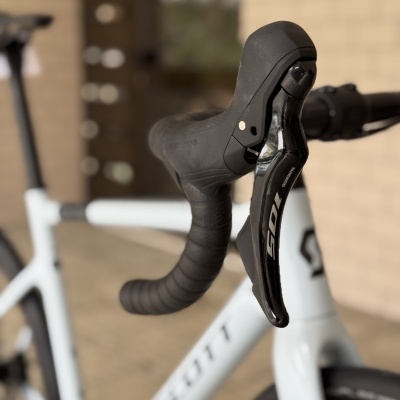 Guiador de bicicleta branca SCOTT com caixa de mudanças Shimano 105 preta