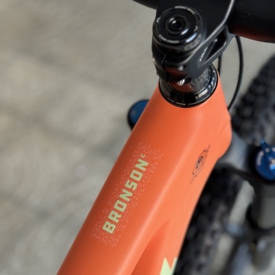 Quado laranja fosco de bicicleta com texto BRONSON em amarelo e guiador preto