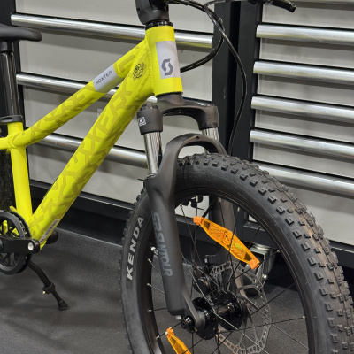 Bicicleta de montanha amarela com quadro estampado, pneus KENDA, garfo SR SUNTOUR e componentes Shimano