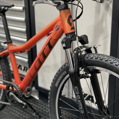 Bicicleta de montanha laranja com garfo de suspensão e pneus largos