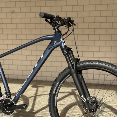 Bicicleta de montanha com quadro azul escuro e garfo preto