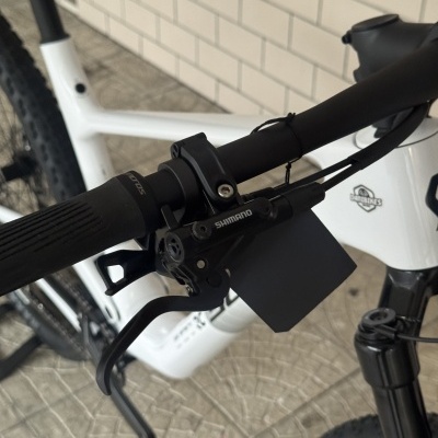 Bicicleta branca com componente SHIMANO no guiador preto