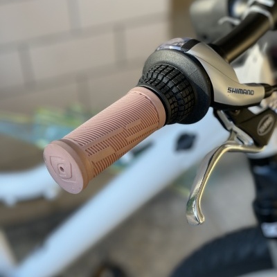 Punho de bicicleta rosa com manete SHIMANO ao fundo