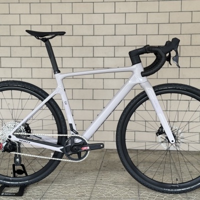 Bicicleta de estrada branca com rodas pretas apoiada num suporte