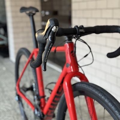 Bicicleta de estrada vermelha com detalhes em preto numa garagem