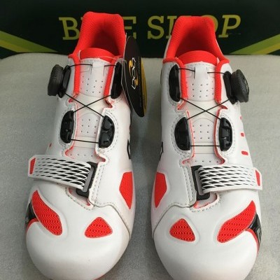 Sapatos de ciclismo brancos e vermelhos com fecho de rosca e fivela