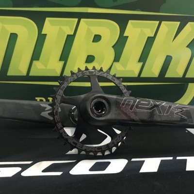 pedaleira NEXT R carbono preta com coroa dentada e fundo verde com texto ANIRIKE