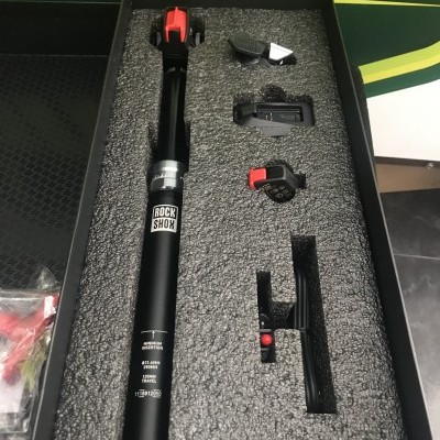 Suspensão de bicicleta RockShox preta com acessórios em caixa preta
