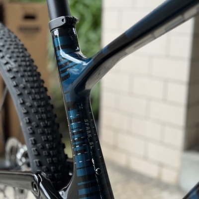 Quadro de bicicleta de montanha carbono preto e azul com texto SPARK SL.