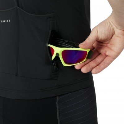 Colete preto Oakley com bolso onde são guardados óculos de sol amarelos neon com lentes espelhadas roxas e vermelhas