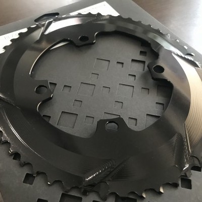 pedaleira preta metálica para bicicleta sobre mesa de madeira