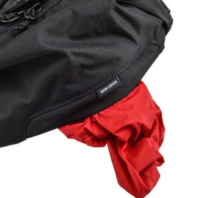 Capa de chuva preta com etiqueta e tecido vermelho por baixo