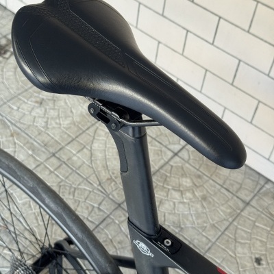 Selim de bicicleta preto e detalhe do quadro preto com detalhes vermelhos