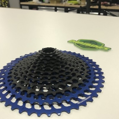 Roda dentada para bicicleta azul e preta sobre mesa branca