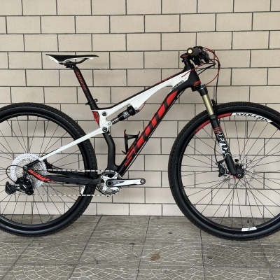 Bicicleta de montanha preta, branca e vermelha com suspensão e vários logos
