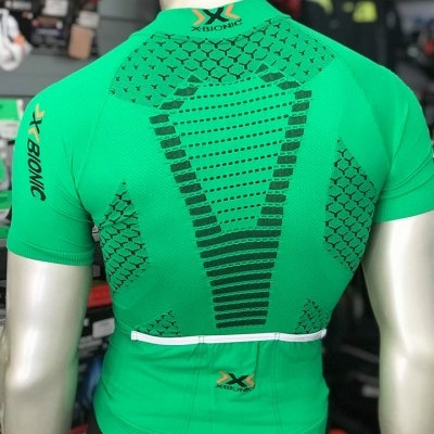 Camisola de ciclismo verde com padrões pretos e textos X-BIONIC e X-TECHNOLOGY vista de trás.