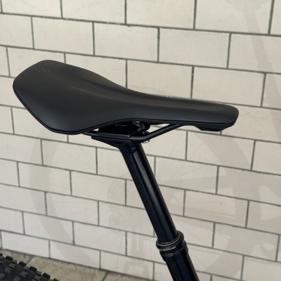 Selim de bicicleta preto com estrutura metálica preta montado num tubo de selim ajustável