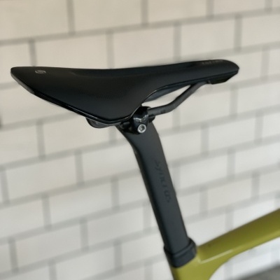 Selim de bicicleta preto em quadro verde com fundo de parede branca