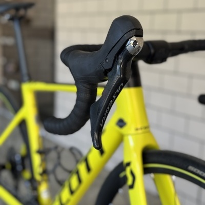 Bicicleta de estrada amarela com manete de travão ULTEGRA e guiador preto