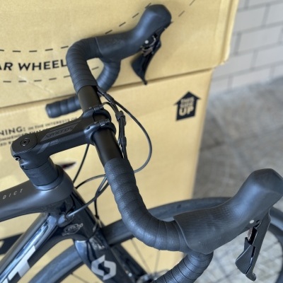 Bicicleta de estrada preta com guiador curvo e fita preta