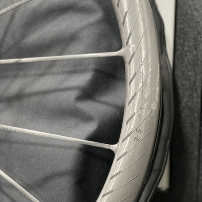 Roda de bicicleta cinza com raios finos sobre fundo preto