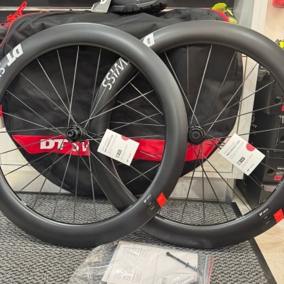 Duas rodas de bicicleta de estrada em carbono preto fosco com etiquetas e capa preta e vermelha