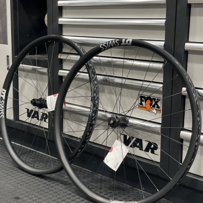 Duas rodas de bicicleta com aro preto encostadas num armário metálico.