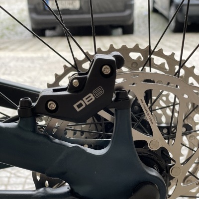 Travão de disco hidráulico DB8 em roda traseira de bicicleta com disco prateado e raios pretos