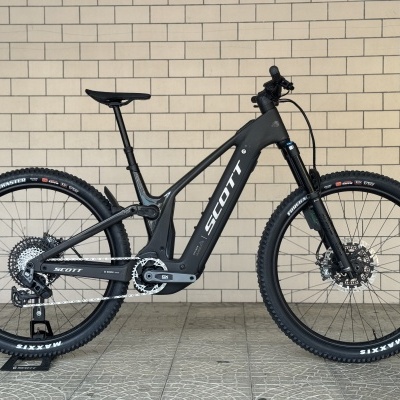 Bicicleta eléctrica de montanha SCOTT preta encostada a uma parede de tijolos