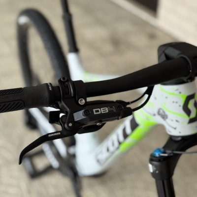 Bicicleta branca e verde com sistema de travão SRAM DB4 no guiador