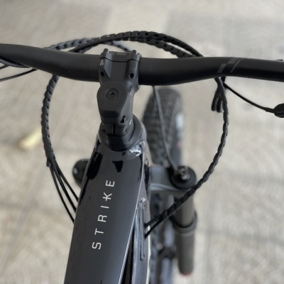 Guiador e quadro preto de bicicleta de montanha com nome STRIKE visível