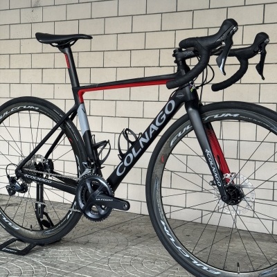 Bicicleta de estrada COLNAGO preto, cinza e vermelho com rodas Fulcrum.